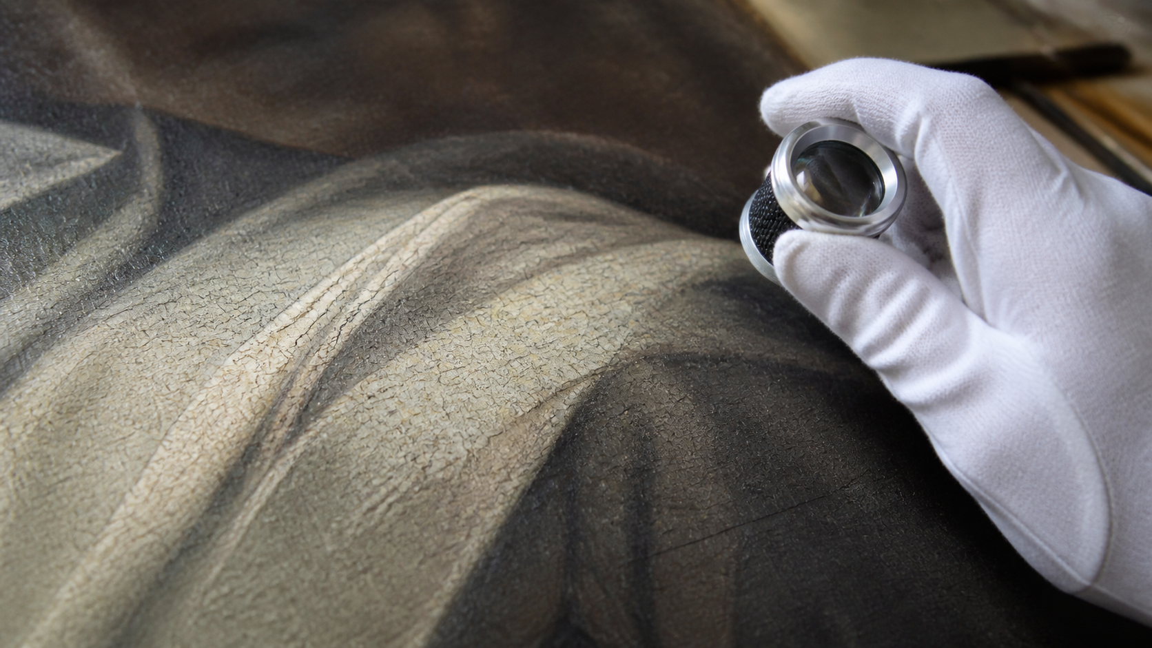 Detalle de una pintura al óleo anónima con craquelado examinado mediante una lupa de conservación