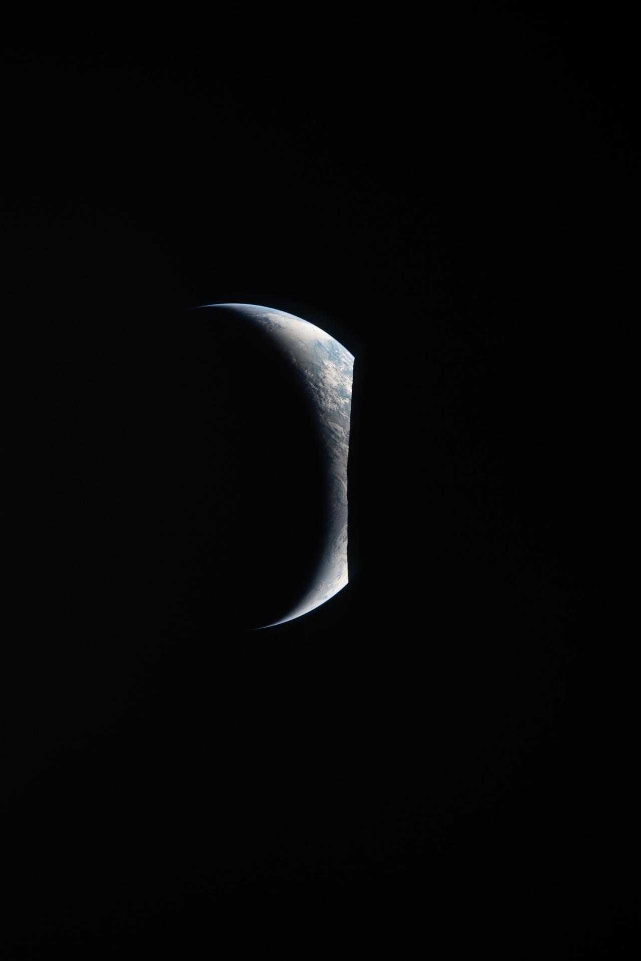La Tierra asomando iluminada sobre el borde oscuro de la Luna en una foto de Artemis II